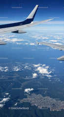 Modern Commercial Airplane Wings Flying Over Blue Sky and Clouds