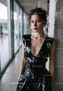 Young Woman in Black Vinyl Dress Posing in Modern Urban Setting