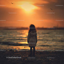 Silhouette of a Child at Sunset by the Ocean Shore