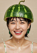 Smiling woman wearing watermelon helmet with water drops