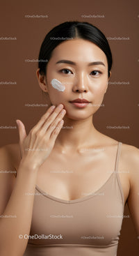 Young Asian Woman Applying Facial Moisturizer for Healthy Skin