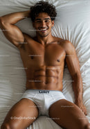Relaxed young man smiling while lying on bed
