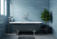 Classic freestanding bathtub with green plant in blue tiled bathroom