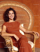 Confident woman smiling while seated in wicker chair