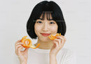Close-up of Happy Woman Enjoying Fresh Tangerine Slices for Healthy Lifestyle