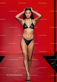 Elegant Female Model Walking on Fashion Runway in Black Bikini