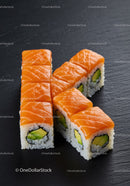 Fresh salmon sushi rolls with avocado on black slate