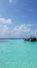 Turquoise Ocean with Overwater Bungalows and Clear Blue Sky Scenic View
