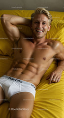 Smiling young man relaxing on yellow bedding in white underwear