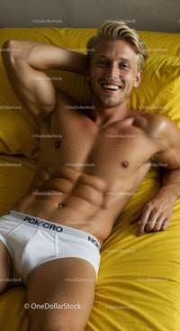 Smiling young man relaxing on yellow bedding in white underwear