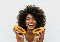 Joyful Woman Holding Fresh Papayas with Bright Smile