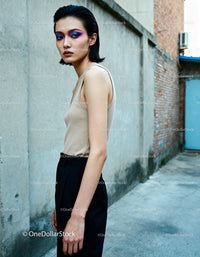 Young woman with colorful eye makeup posing outdoors