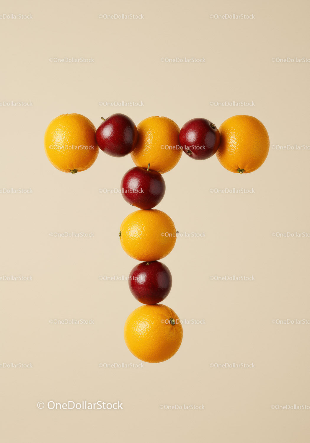 Creative arrangement of apples and oranges forming letter T
