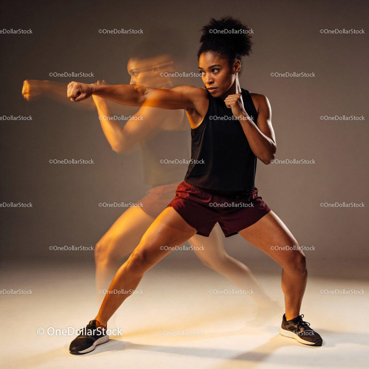 Athletic woman practicing boxing punch with motion blur