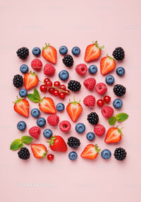 Fresh assorted berries scattered on pastel pink background