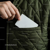 Hand placing white card into quilted jacket pocket