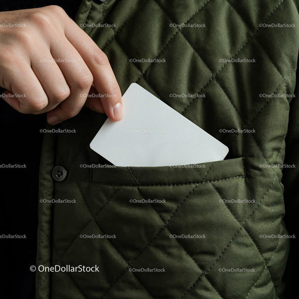 Hand placing white card into quilted jacket pocket JPG Mockup Image