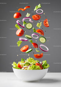 Fresh garden vegetables floating into white bowl salad
