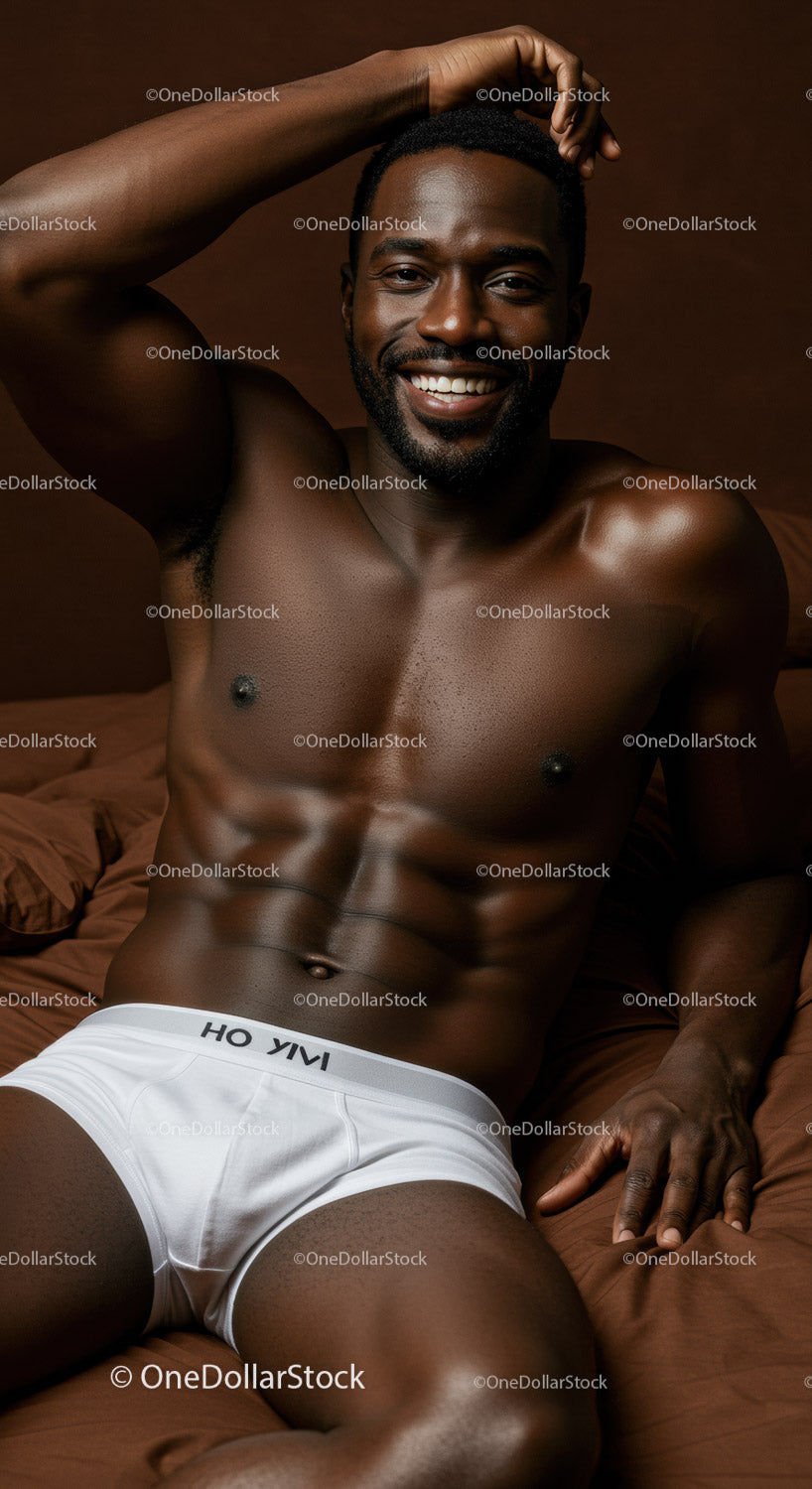 Smiling muscular man relaxing on brown bed linen