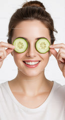 Joyful Woman with Cucumber Slices Over Eyes for Relaxation and Skincare