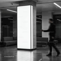 Blurred man walking past illuminated pillar in modern lobby