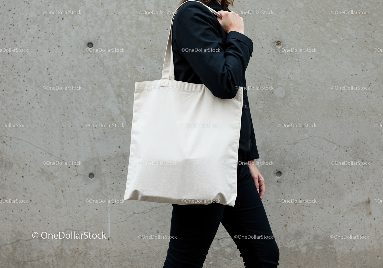 Person carrying blank canvas tote bag on shoulder