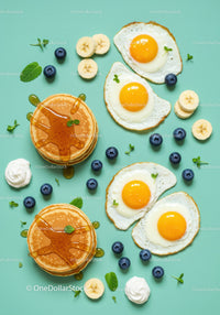 Fresh breakfast with pancakes, eggs, and fruits on blue