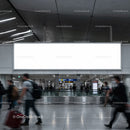 Busy modern airport terminal with blank billboard