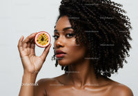 Portrait of a Beautiful Black Woman Holding Passion Fruit with Curly Hair