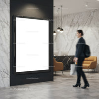 Businesswoman walking past blank digital poster in lobby