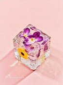 Frozen edible flowers inside a clear ice cube