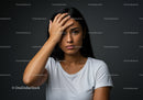 Young Woman Expressing Frustration and Stress Against Dark Background