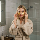 Woman Applying Gold Eye Patches for Beauty and Rejuvenation