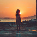 Silhouette of a Child at Sunset by the Ocean Shore