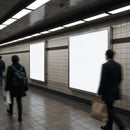 Commuters walking past illuminated blank posters in subway