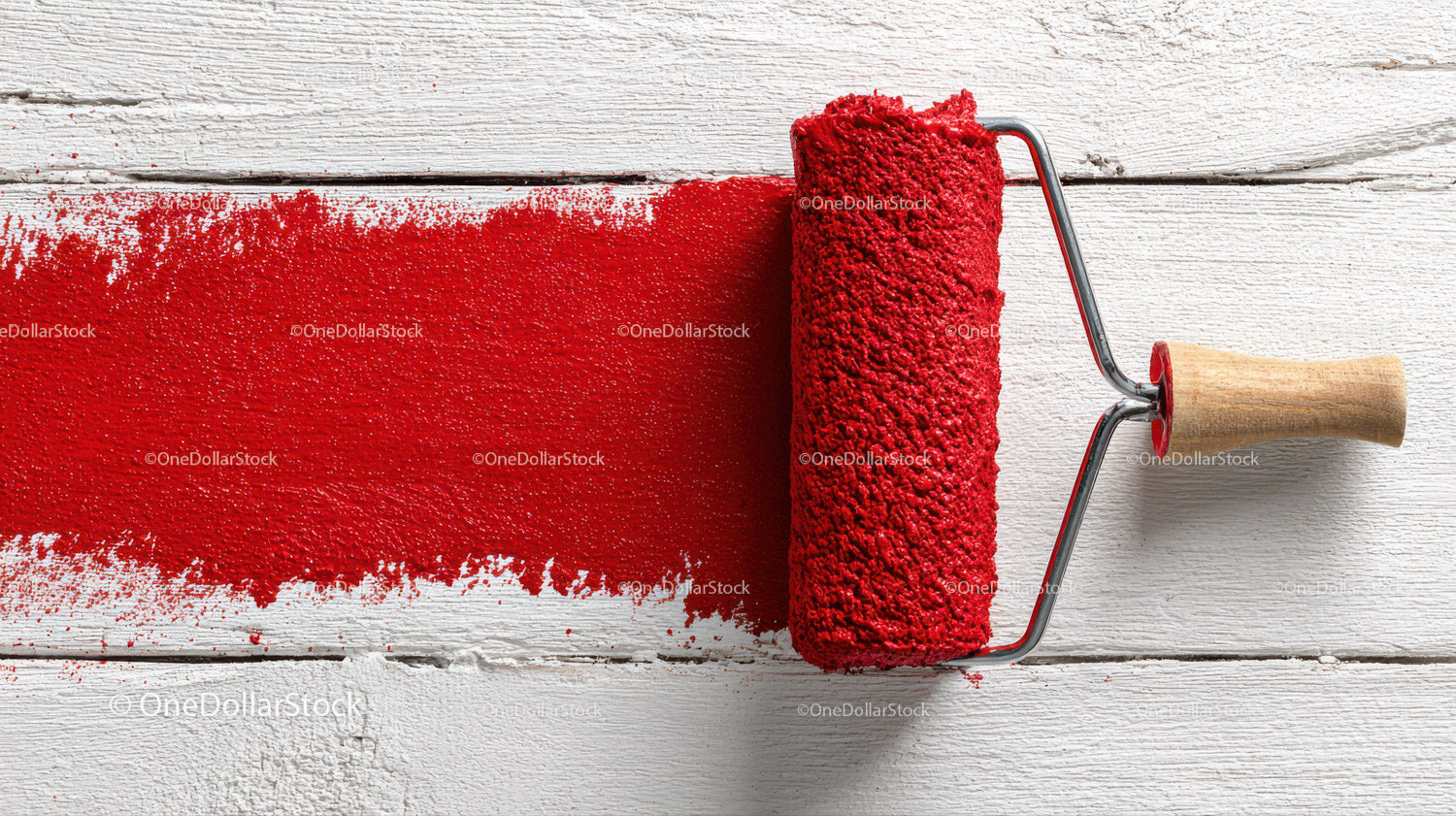 Red Paint Roller Spreading Bright Red Coating on White Wooden Wall