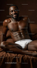 Smiling muscular man relaxing on brown bed linen