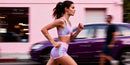 Young woman running energetically along city street