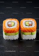Two pieces of fresh salmon sushi with avocado slices