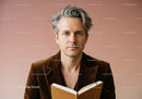 Professional Portrait of a Mature Man with Gray Hair Reading a Book