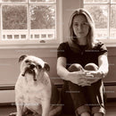 Calm woman sitting with her English Bulldog by window