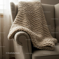 Chunky knit blanket draped over cozy armchair