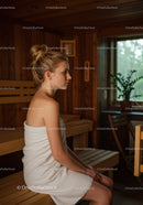 Young Woman Relaxing in Wooden Sauna Room with Towel