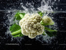 Fresh White Cauliflower with Green Leaves in Water Splash