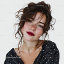 Young Woman with Curly Hair and Freckles Wearing Black Sequin Top