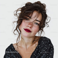 Young Woman with Curly Hair and Freckles Wearing Black Sequin Top
