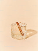 Refreshing iced drink with cinnamon stick on beige background