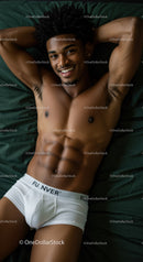 Smiling muscular man relaxing on dark green bed