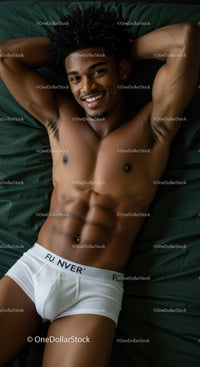 Smiling muscular man relaxing on dark green bed