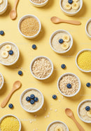 Assorted healthy breakfast bowls with fruits on yellow background